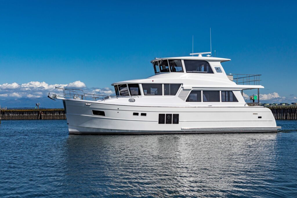 Luxury white North Pacific pilothouse yacht cruising on calm water under blue sky