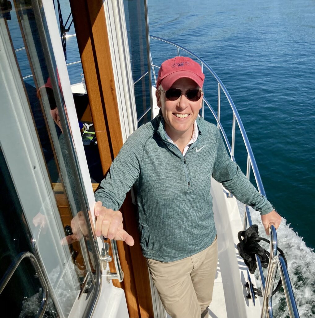 Person enjoying sunny day on North Pacific Yacht deck with ocean background