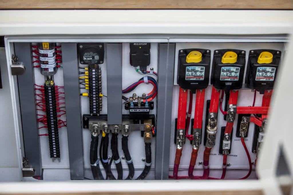 Boat electrical control panel with wiring and circuit breakers on a North Pacific Yacht