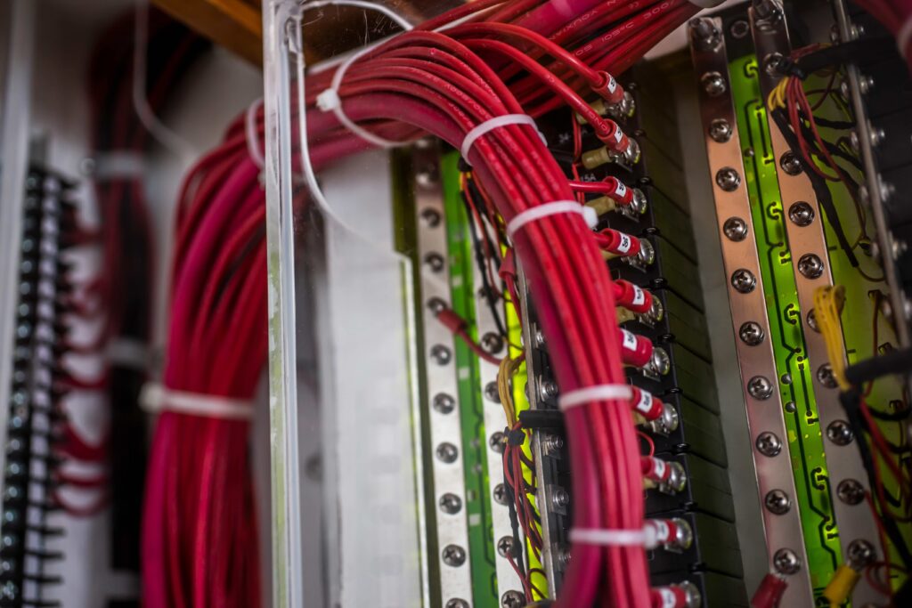 Close-up of organized red marine electrical wiring inside yacht panel