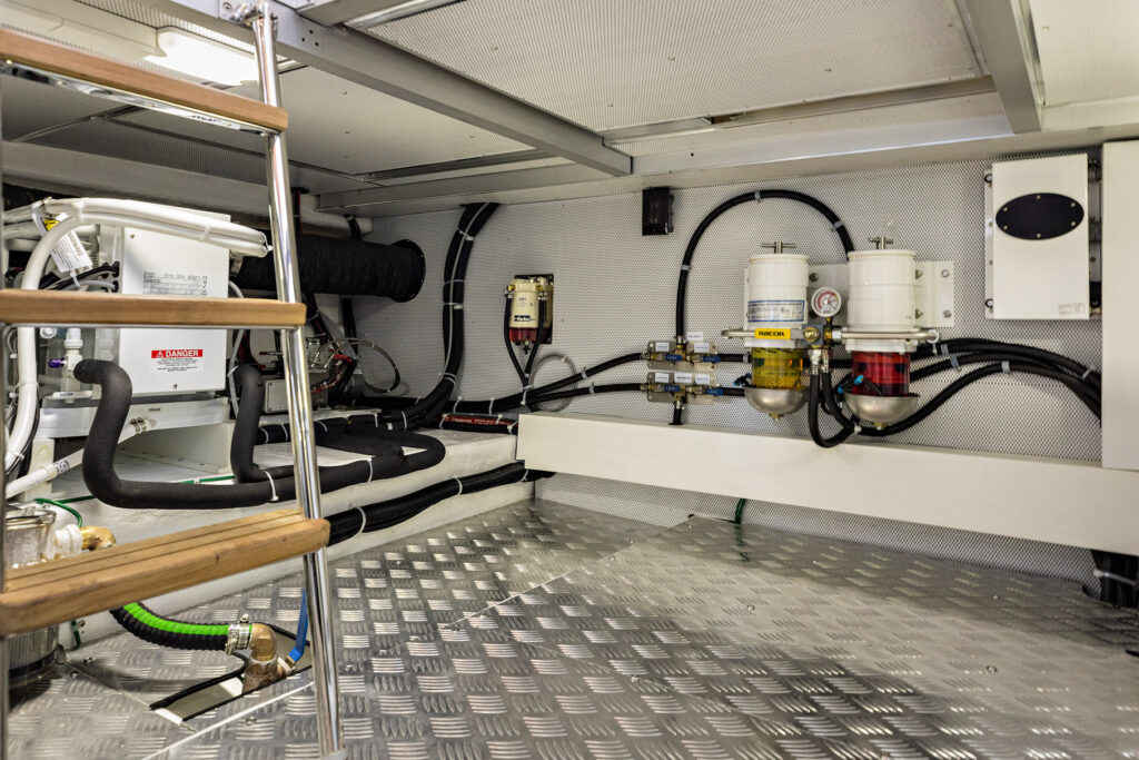 Clean marine engine room with fuel filters and piping on a North Pacific Yacht