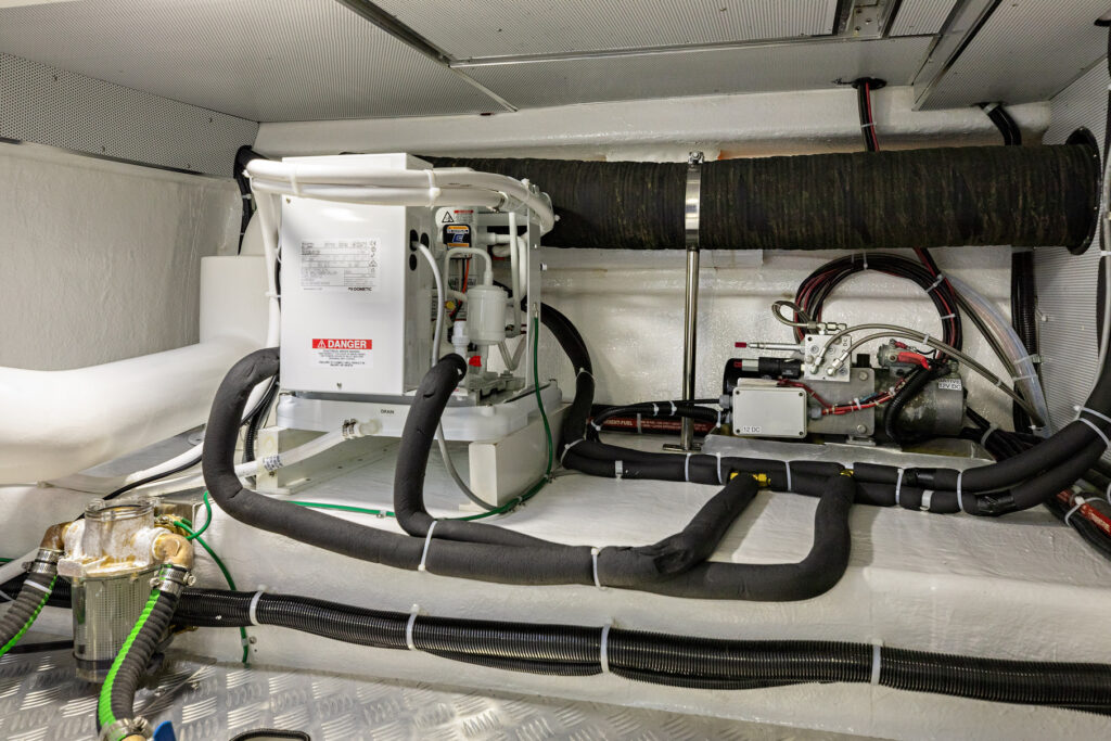 Boat engine room with HVAC system and insulated pipes on North Pacific Yachts pilothouse