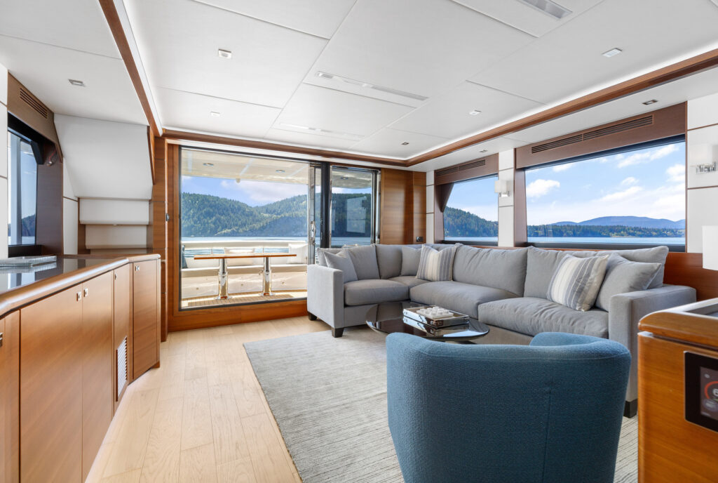 Luxury yacht salon with large windows and outdoor dining view