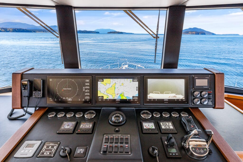 Modern pilothouse helm with navigation screens and ocean view on North Pacific Yacht