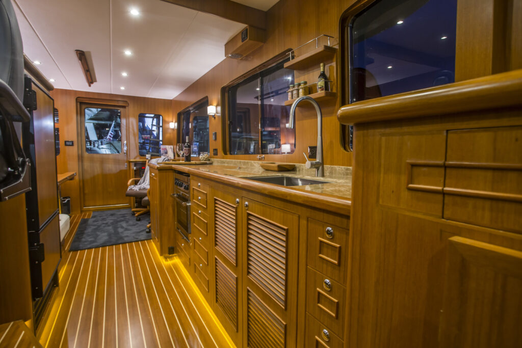 Custom wooden galley kitchen interior on a North Pacific Yacht with modern amenities